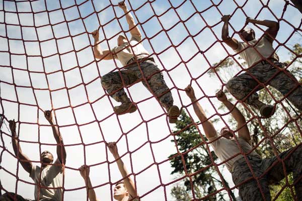 A group of people climbing on top of a net.